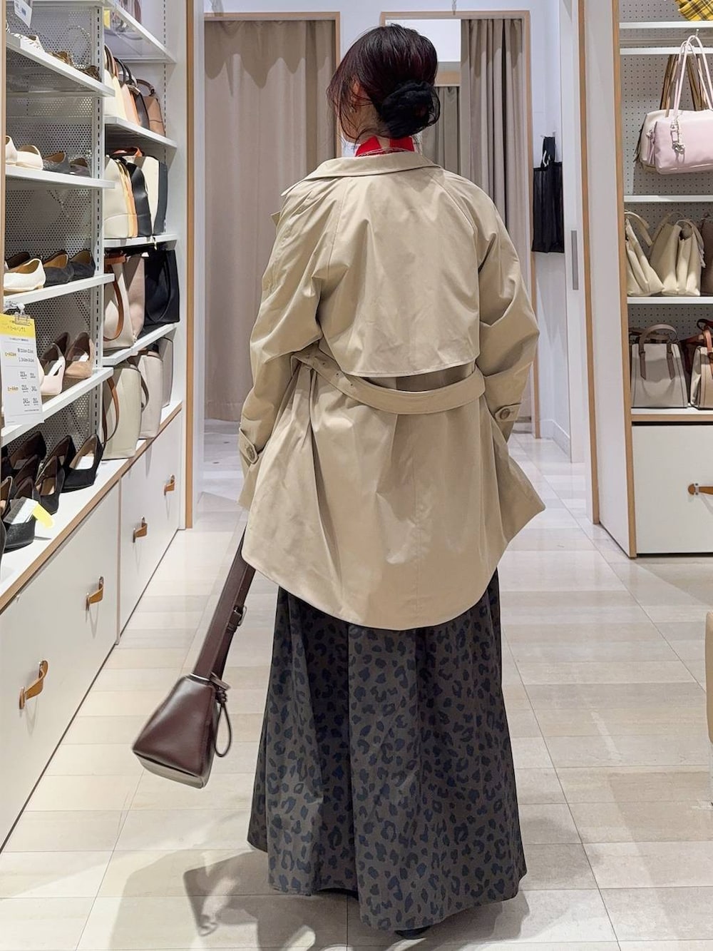 ブラック系のバレエシューズ、レッド系のニット/セーター、ベージュ系のトレンチコートを着用したレディースの冬コーディネートの5枚目の写真