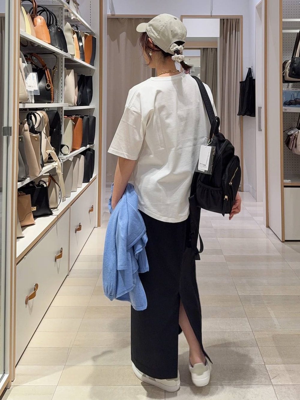 グレー系のスニーカー、ブラック系のバックパック/リュック、ブラック系のスカートを着用したレディースの春コーディネートの7枚目の写真