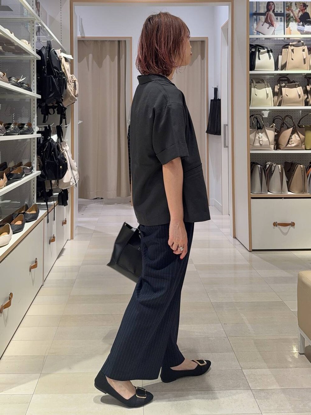 ブラック系のショルダーバッグ、ブラック系のパンプス、ブルー系のその他パンツを着用したレディースの夏コーディネートの4枚目の写真