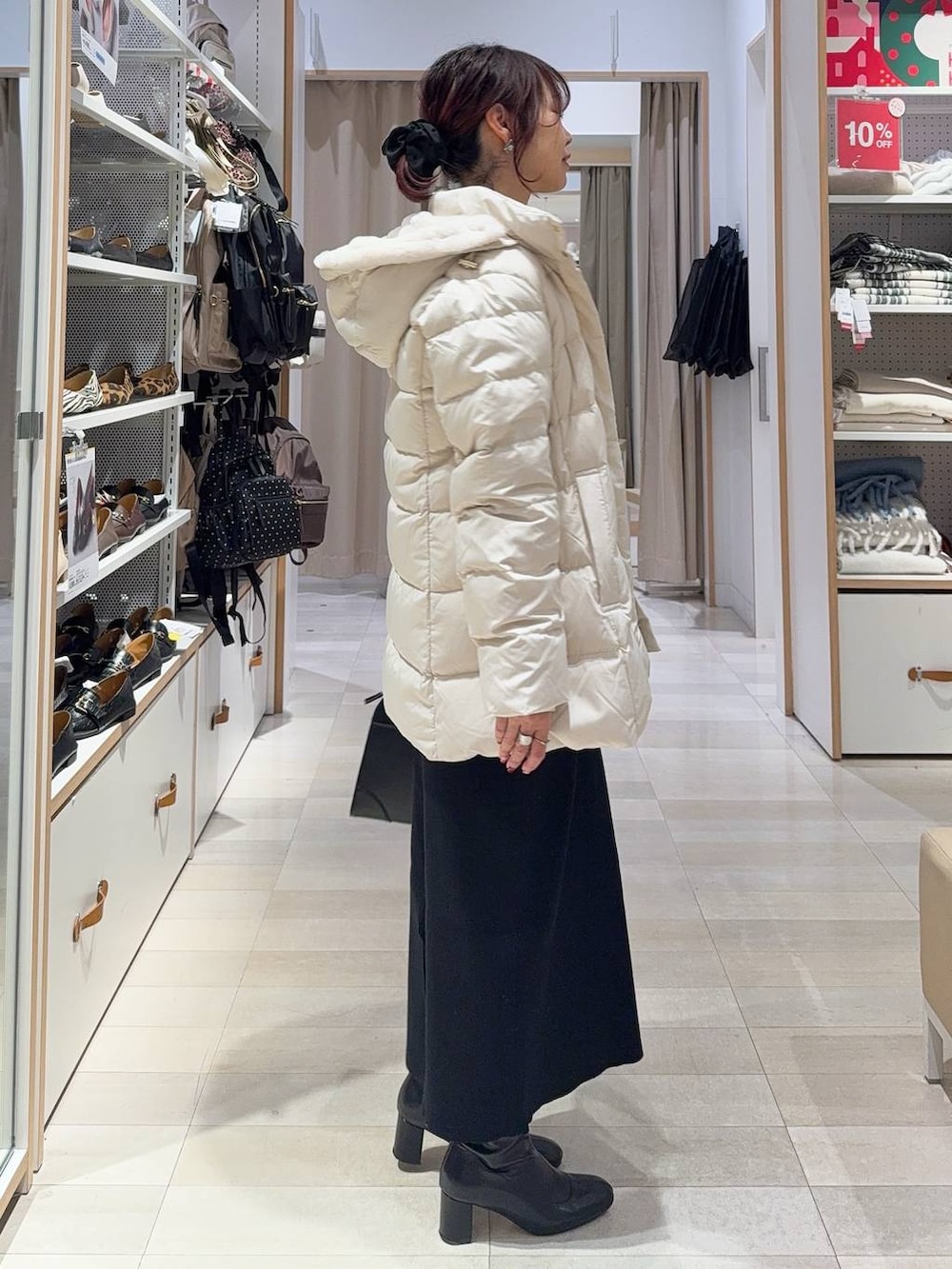 ベージュ系のダウンジャケット/コート、ブラック系のショルダーバッグ、ブラウン系のニット/セーターを着用したレディースの冬コーディネートの4枚目の写真