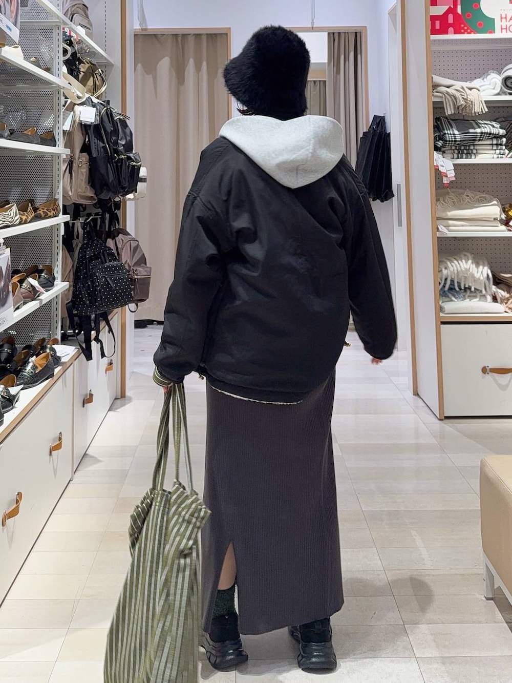 ホワイト系のブルゾン、ブラック系のスニーカー、ホワイト系のTシャツ/カットソーを着用したレディースの冬コーディネートの6枚目の写真