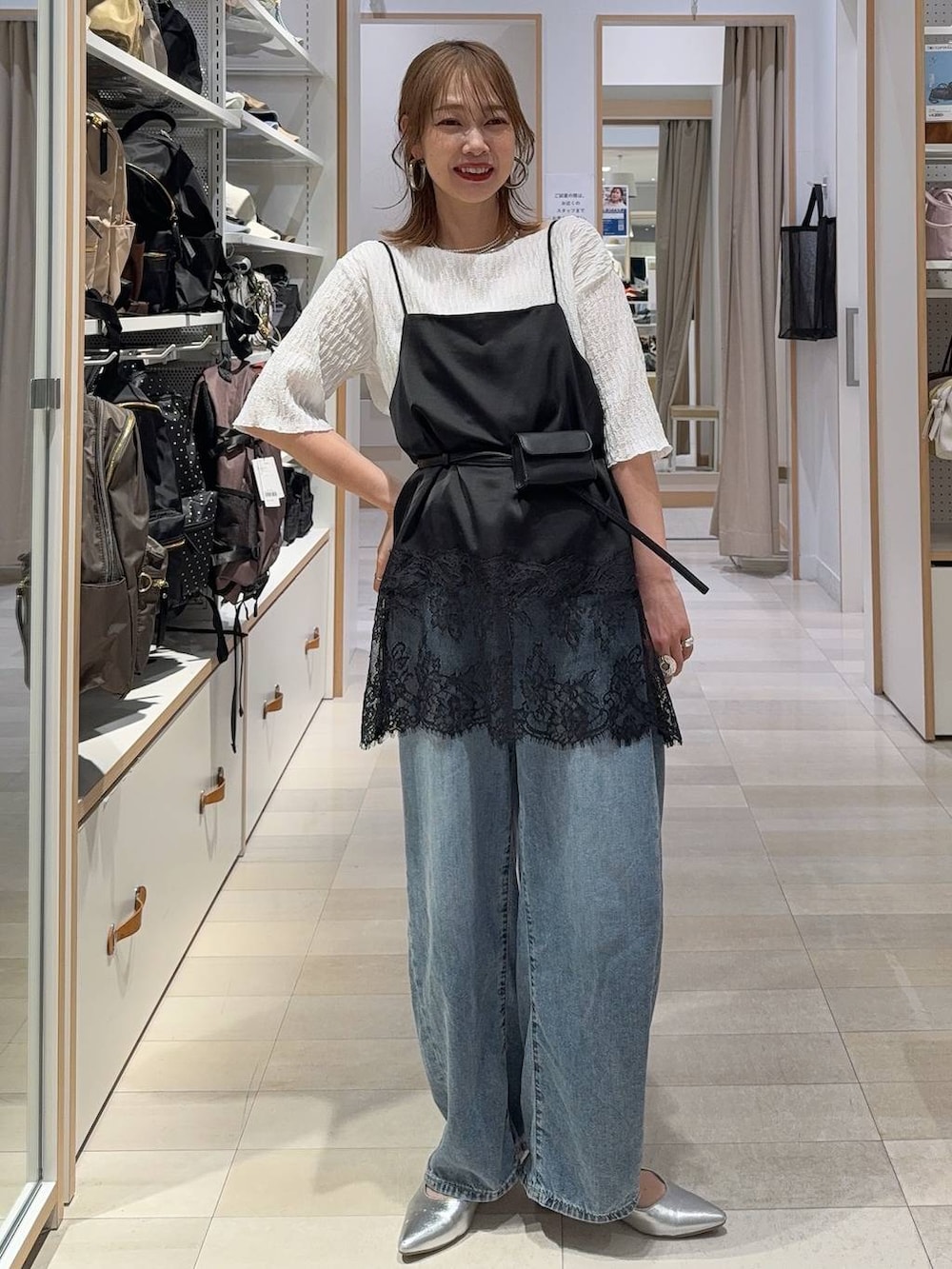 ブルー系のデニムパンツ、ブラック系のキャミソール、ブルー系のカーディガン/ボレロを着用したレディースの春コーディネートの4枚目の写真