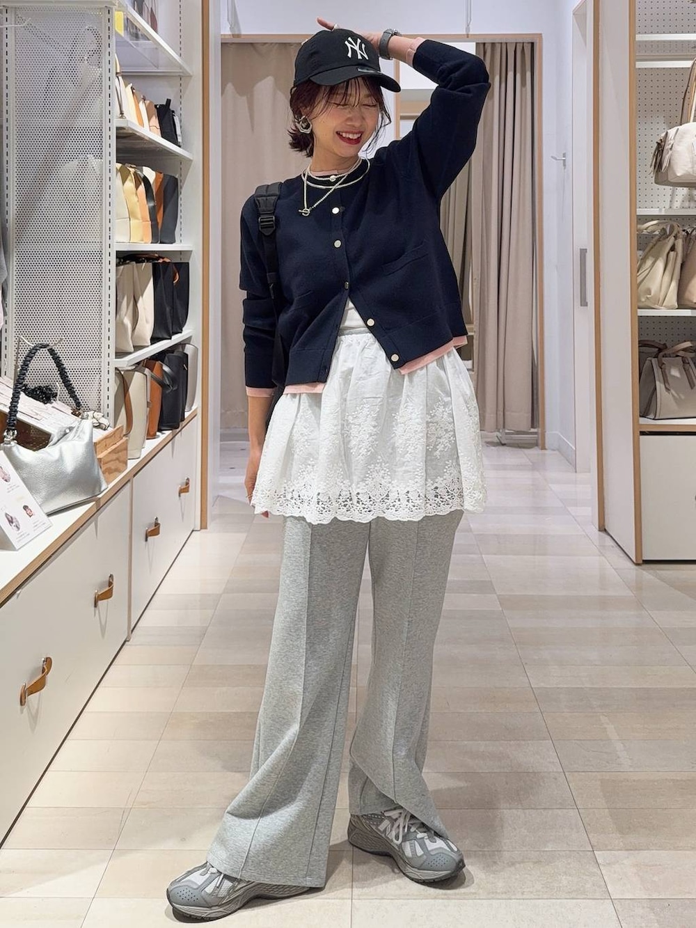 ブラック系のハンドバッグ、ブラウン系のカーディガン/ボレロ、ブラック系のパンプスを着用したレディースの冬コーディネートの2枚目の写真