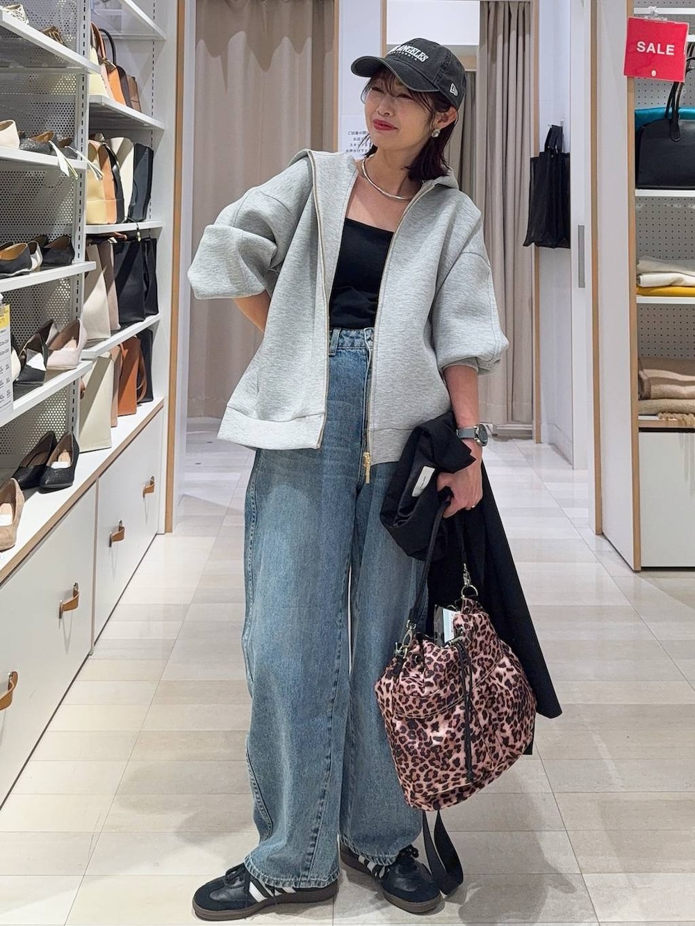 ブラック系のキャミソール、ブラック系のテーラードジャケット、ブルー系のデニムパンツを着用したレディースの冬コーディネートの2枚目の写真