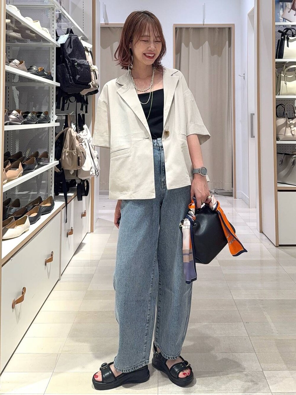 ブラック系のショルダーバッグ、ブラック系のスカート、ブラック系のサンダルを着用したレディースの夏コーディネートの4枚目の写真