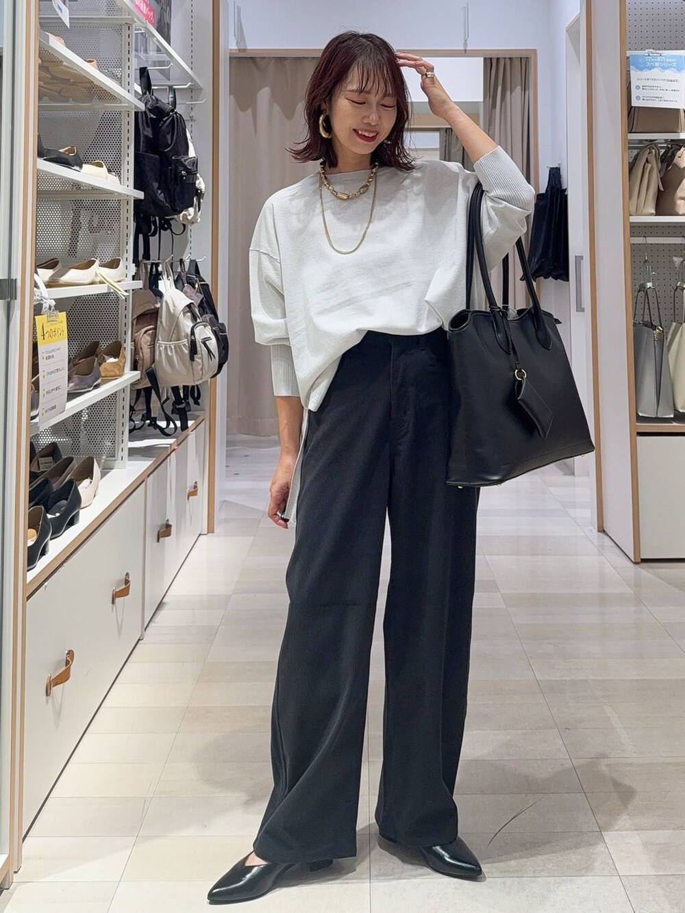 ベージュ系のスニーカー、グリーン系のスウェット、グレー系のトートバッグを着用したレディースの秋コーディネートの2枚目の写真