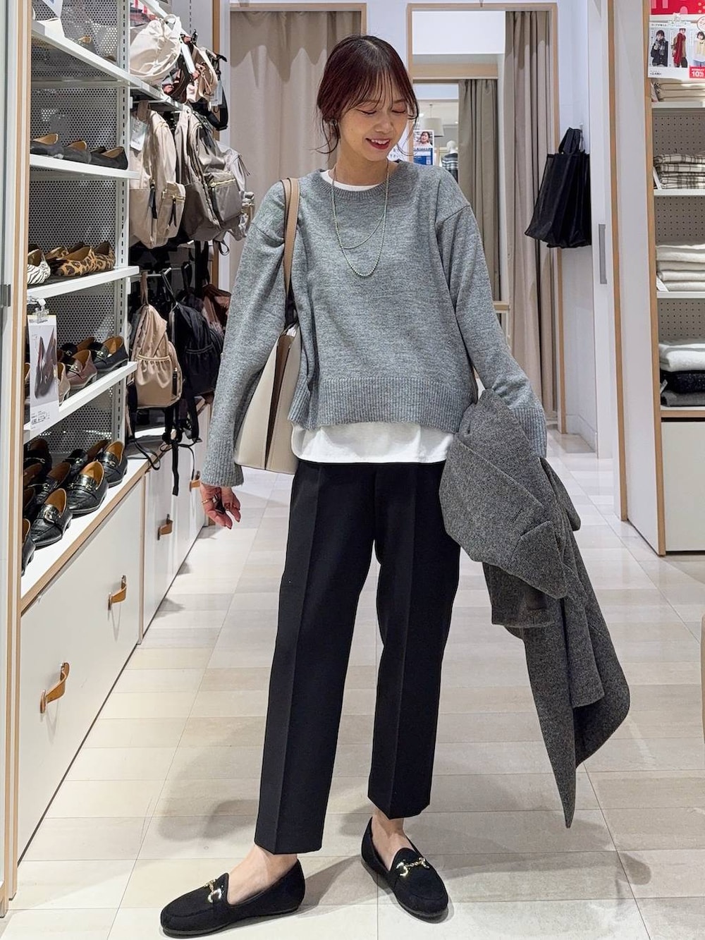 グレー系のチェスターコート、ブラック系のその他パンツ、ホワイト系のTシャツ/カットソーを着用したレディースの冬コーディネートの2枚目の写真