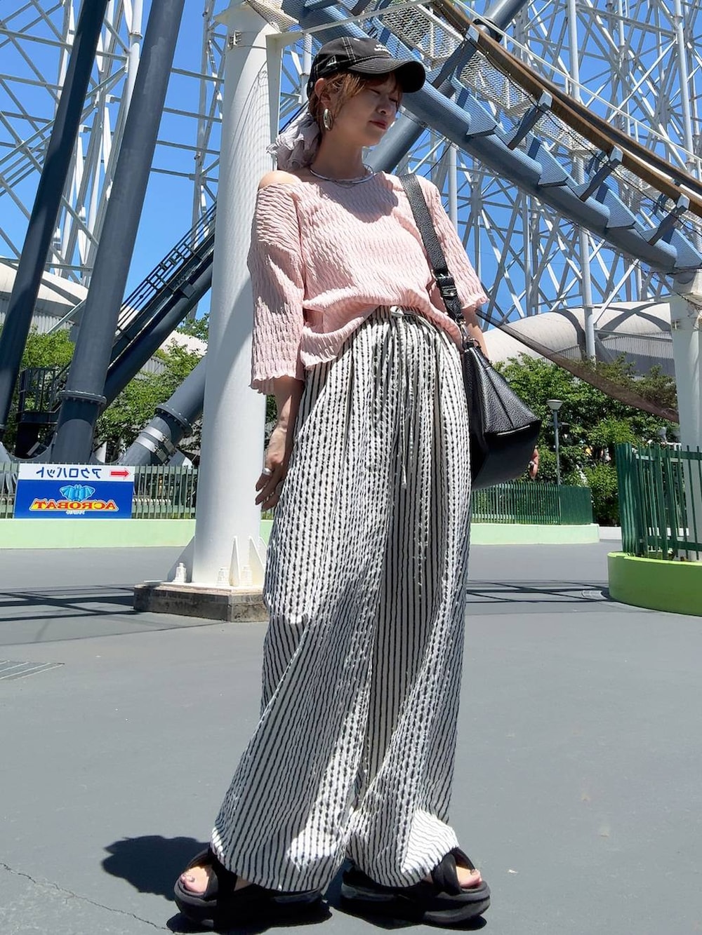 グレー系のTシャツ/カットソー、ブラウン系のサンダル、ホワイト系のその他パンツを着用したレディースの夏コーディネートの6枚目の写真