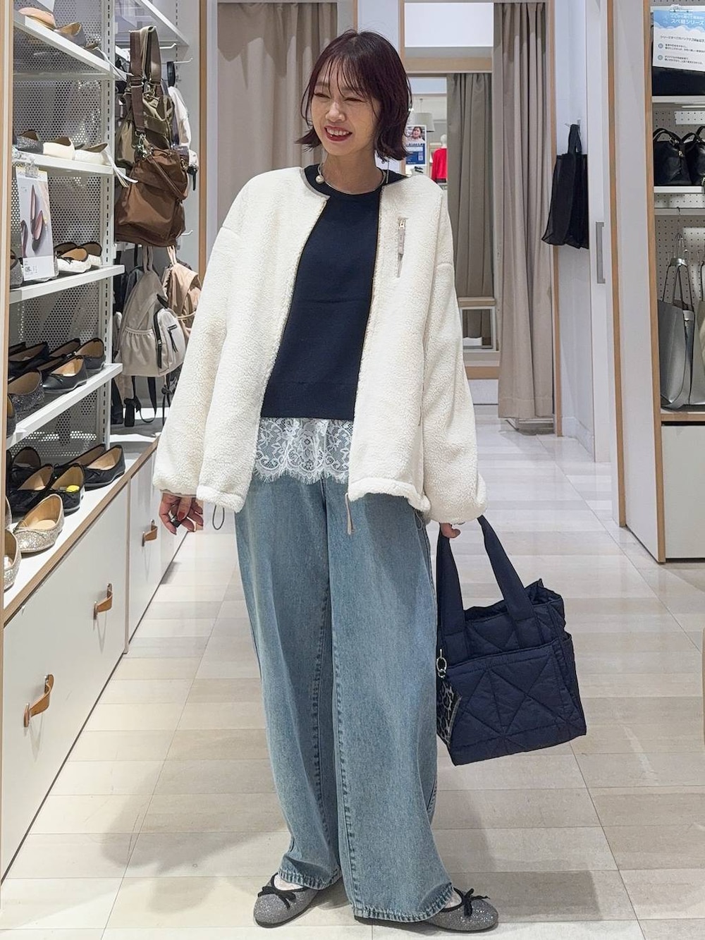 グレー系のバレエシューズ、ブルー系のトートバッグ、ホワイト系のブルゾンを着用したレディースの秋コーディネートの2枚目の写真