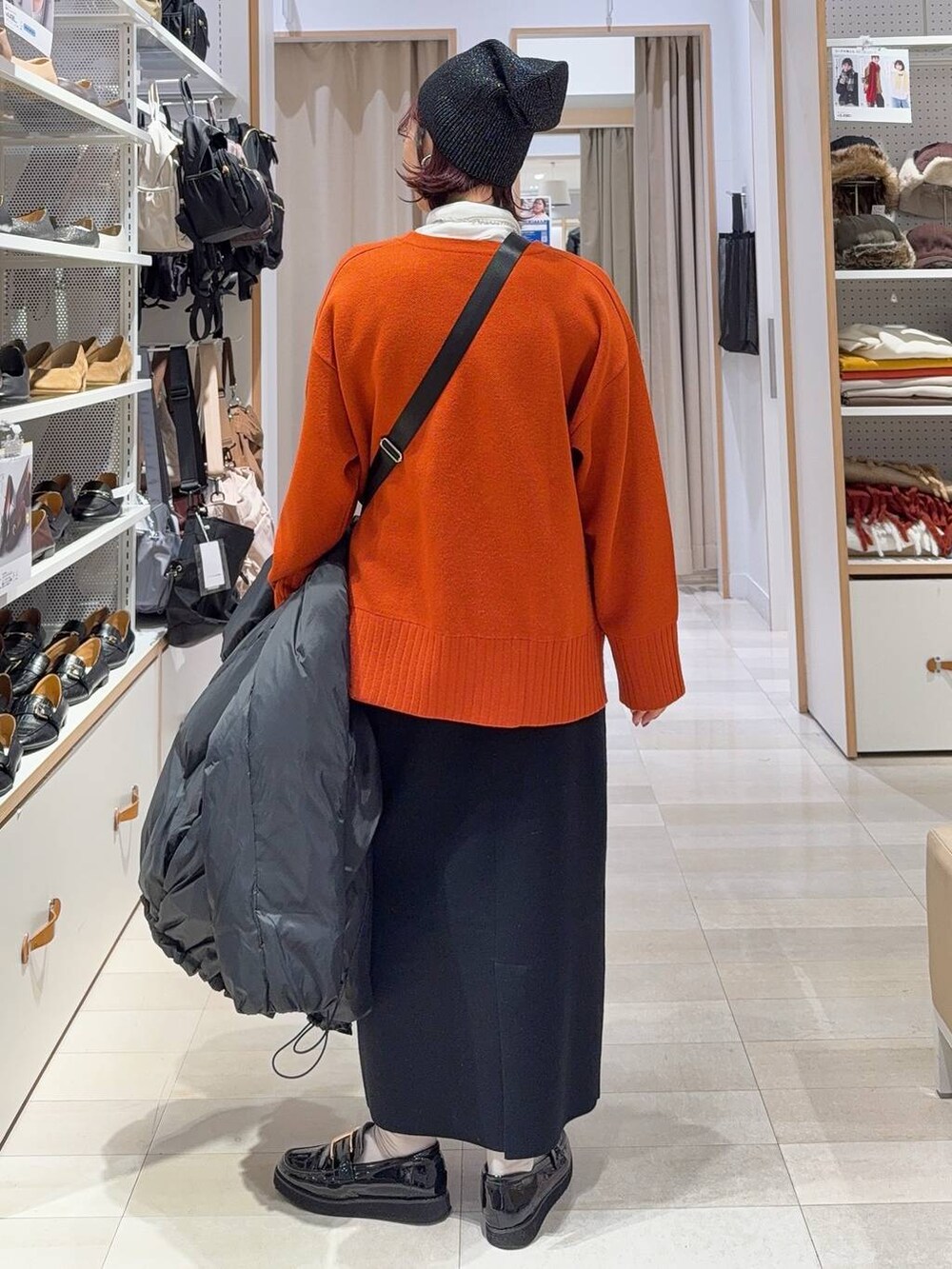 ブラック系のローファー、ブラック系のショルダーバッグ、ブラック系のダウンジャケット/コートを着用したレディースの冬コーディネートの9枚目の写真