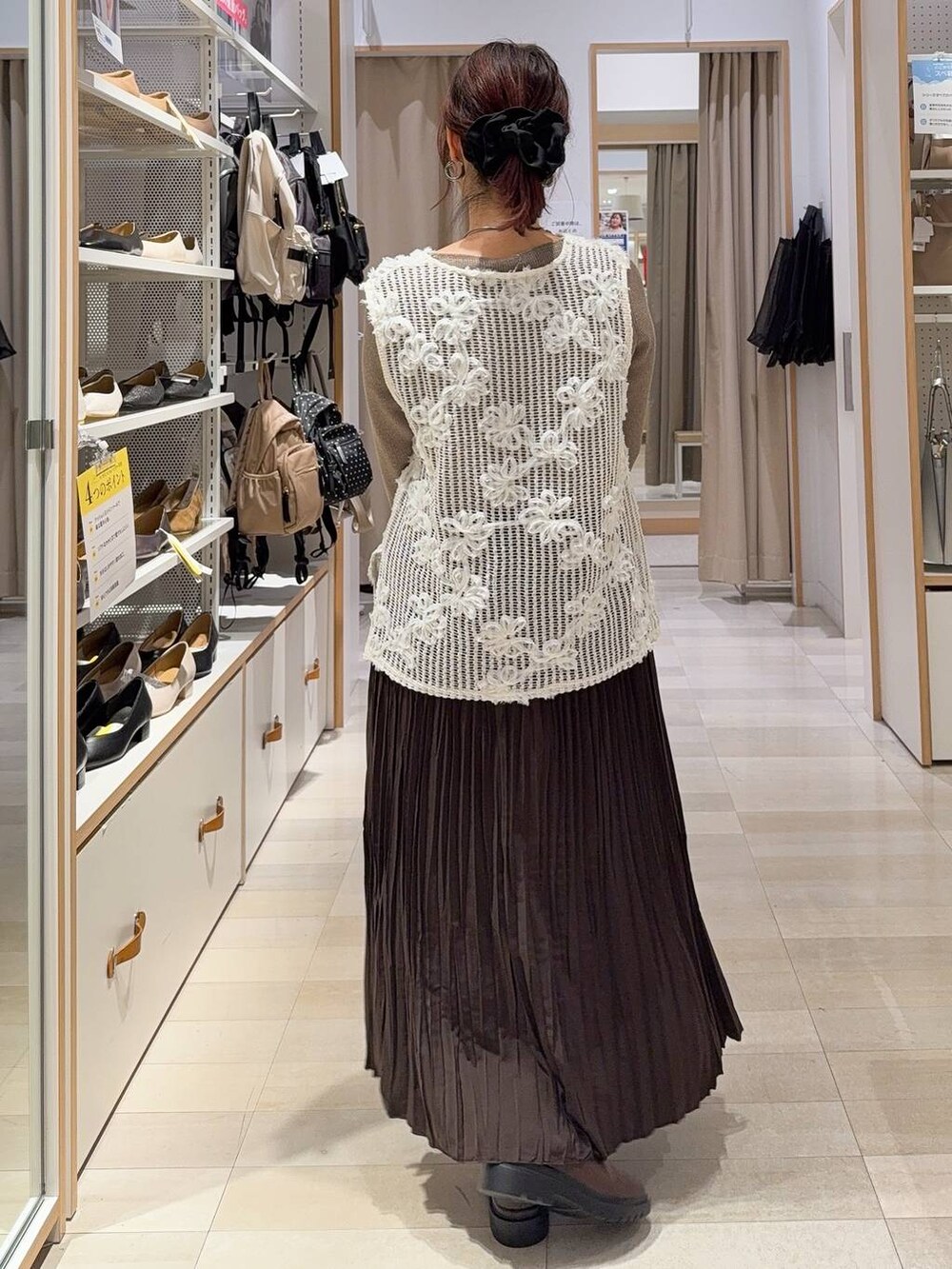 ブラック系のショルダーバッグ、ベージュ系のニット/セーター、ブラウン系のブーツを着用したレディースの秋コーディネートの5枚目の写真