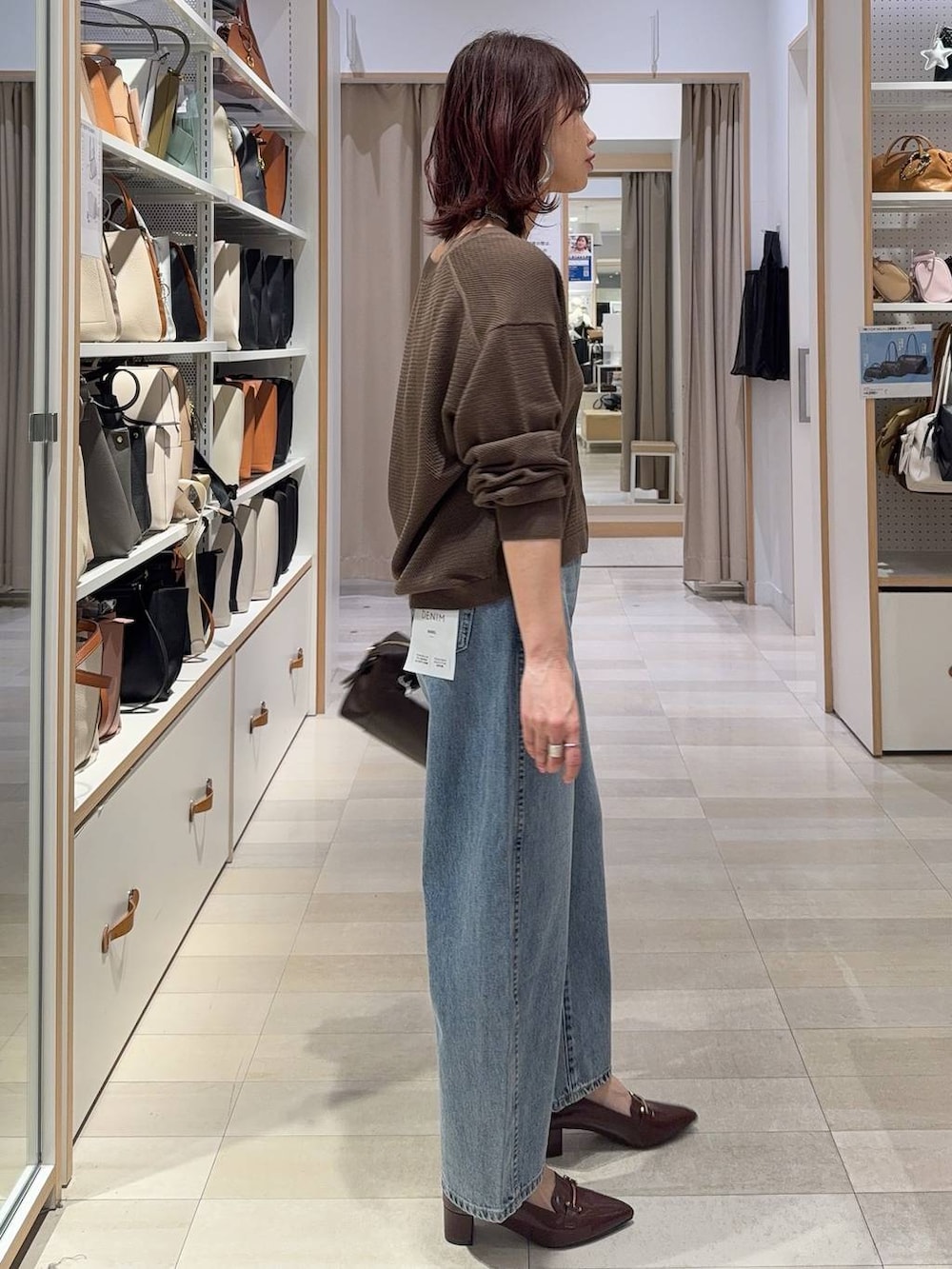 ブルー系のデニムパンツ、ブラウン系のキャミソール、ブラウン系のローファーを着用したレディースの春コーディネートの4枚目の写真