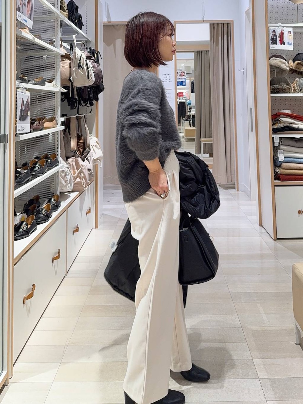 ブラック系のダウンジャケット/コート、ブラック系のトートバッグ、グレー系のその他パンツを着用したレディースの冬コーディネートの5枚目の写真