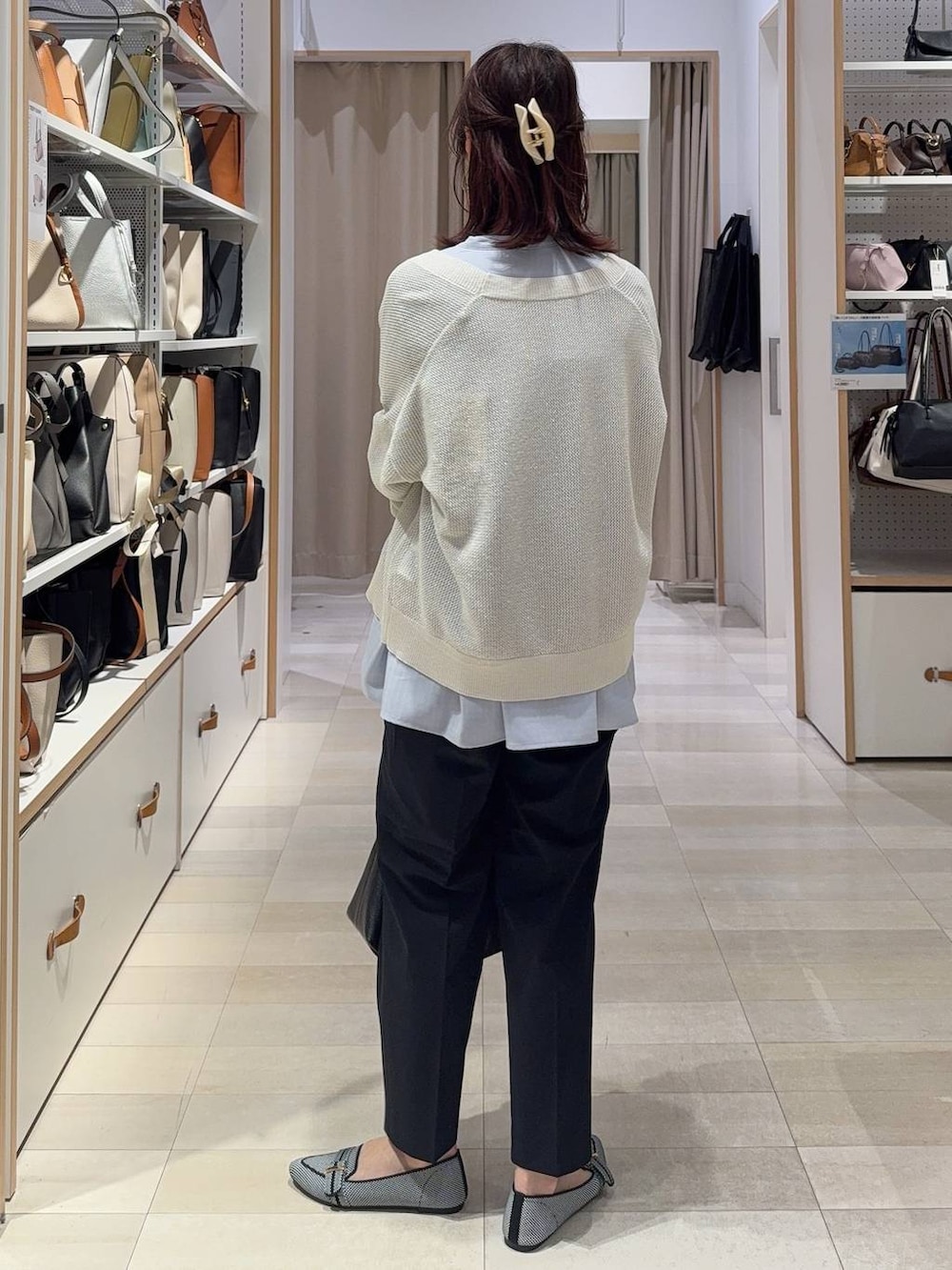 ブラック系のパンプス、ブルー系のスラックス、ホワイト系のカーディガン/ボレロを着用したレディースの春コーディネートの5枚目の写真