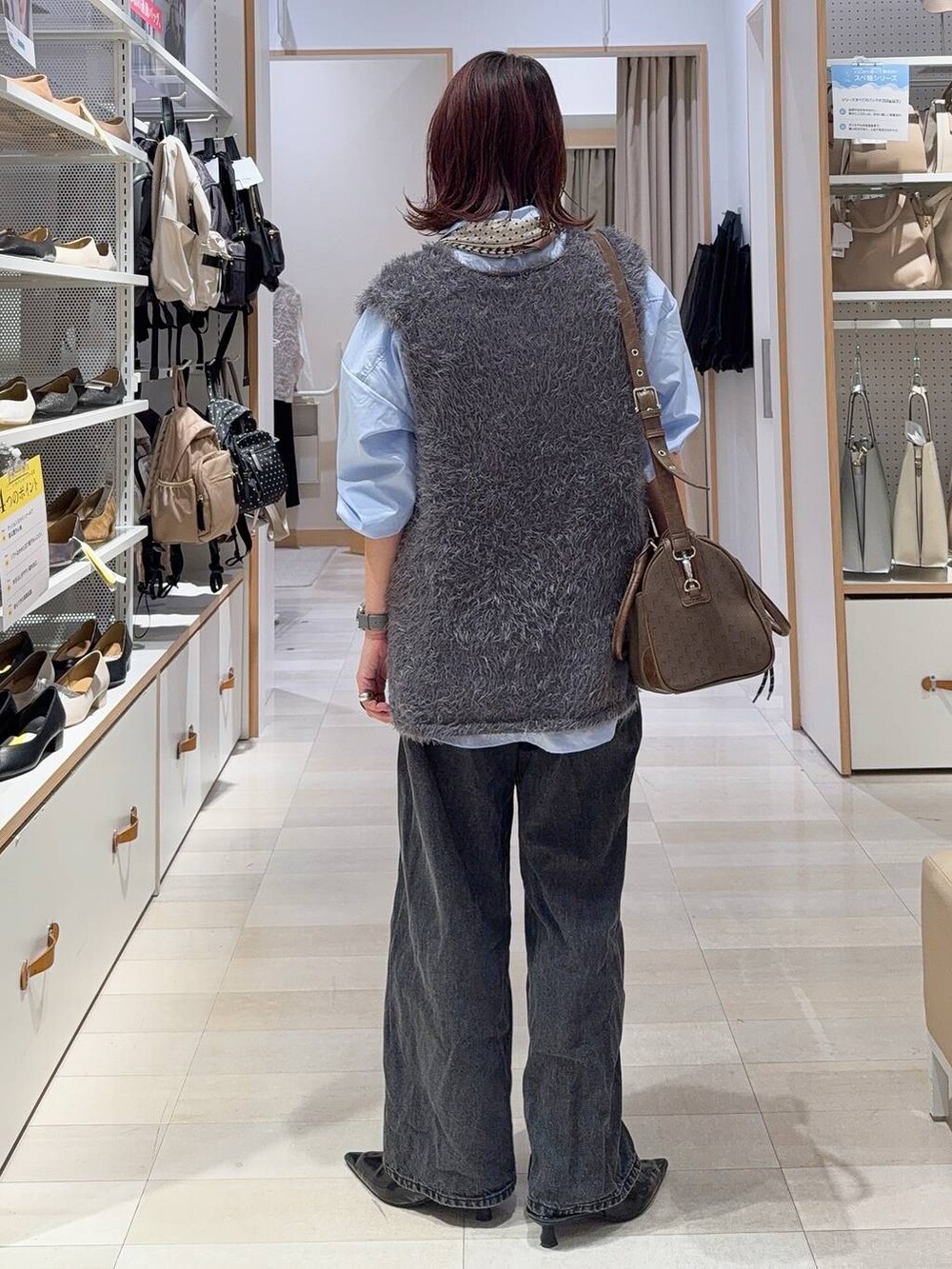 グリーン系のボストンバッグ、ブルー系のシャツ/ブラウス、グレー系のベストを着用したレディースの秋コーディネートの7枚目の写真