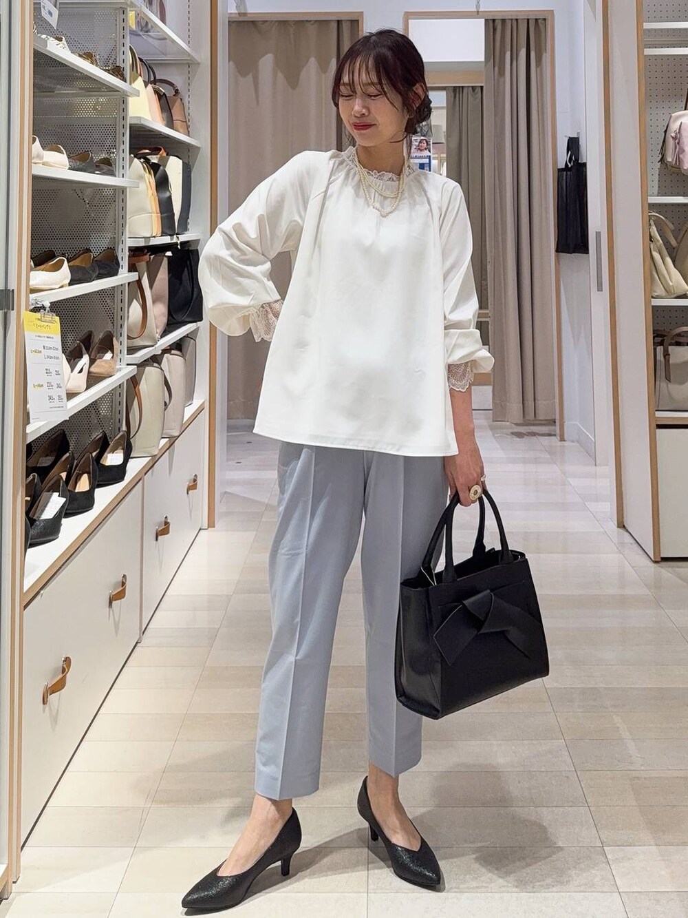 ブラック系のパンプス、ホワイト系のシャツ/ブラウス、ブルー系のスラックスを着用したレディースの冬コーディネートの2枚目の写真