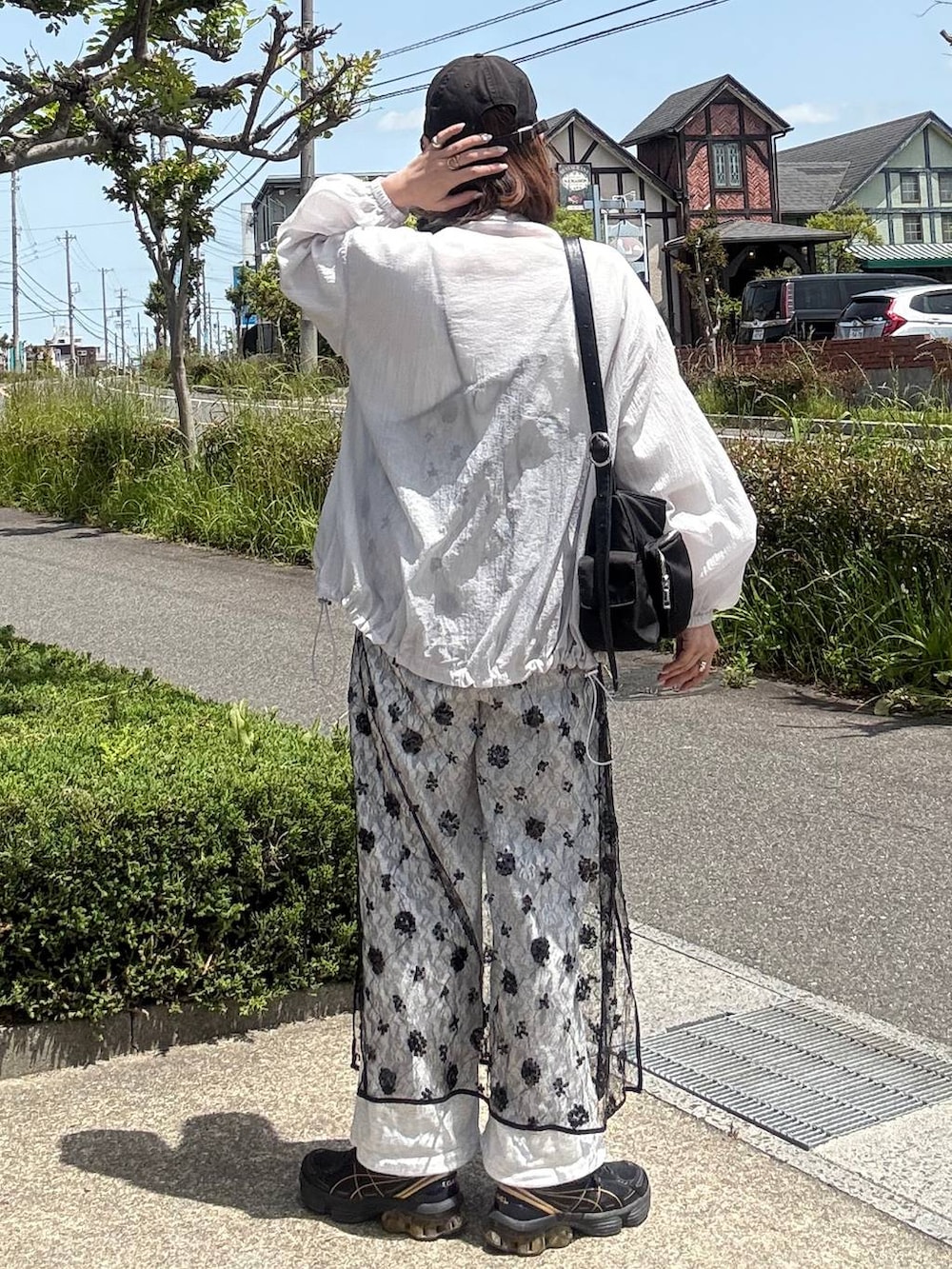 ブラック系のショルダーバッグ、ホワイト系のTシャツ/カットソー、ブラック系のワンピースを着用したレディースの春コーディネートの4枚目の写真