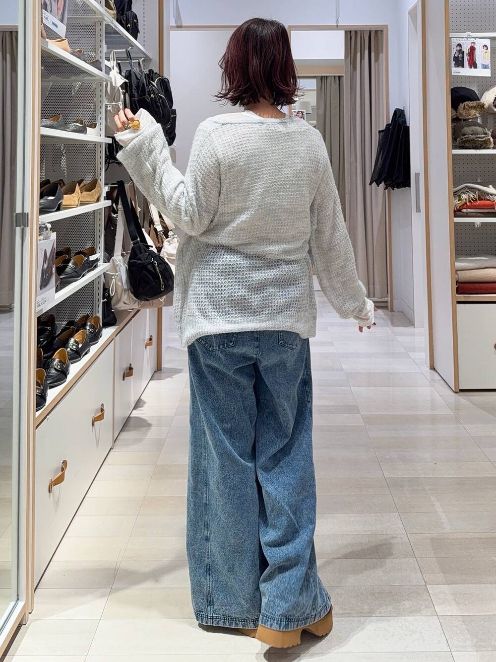 ブラック系のショルダーバッグ、グレー系のニット/セーター、イエロー系のブーツを着用したレディースの冬コーディネートの8枚目の写真