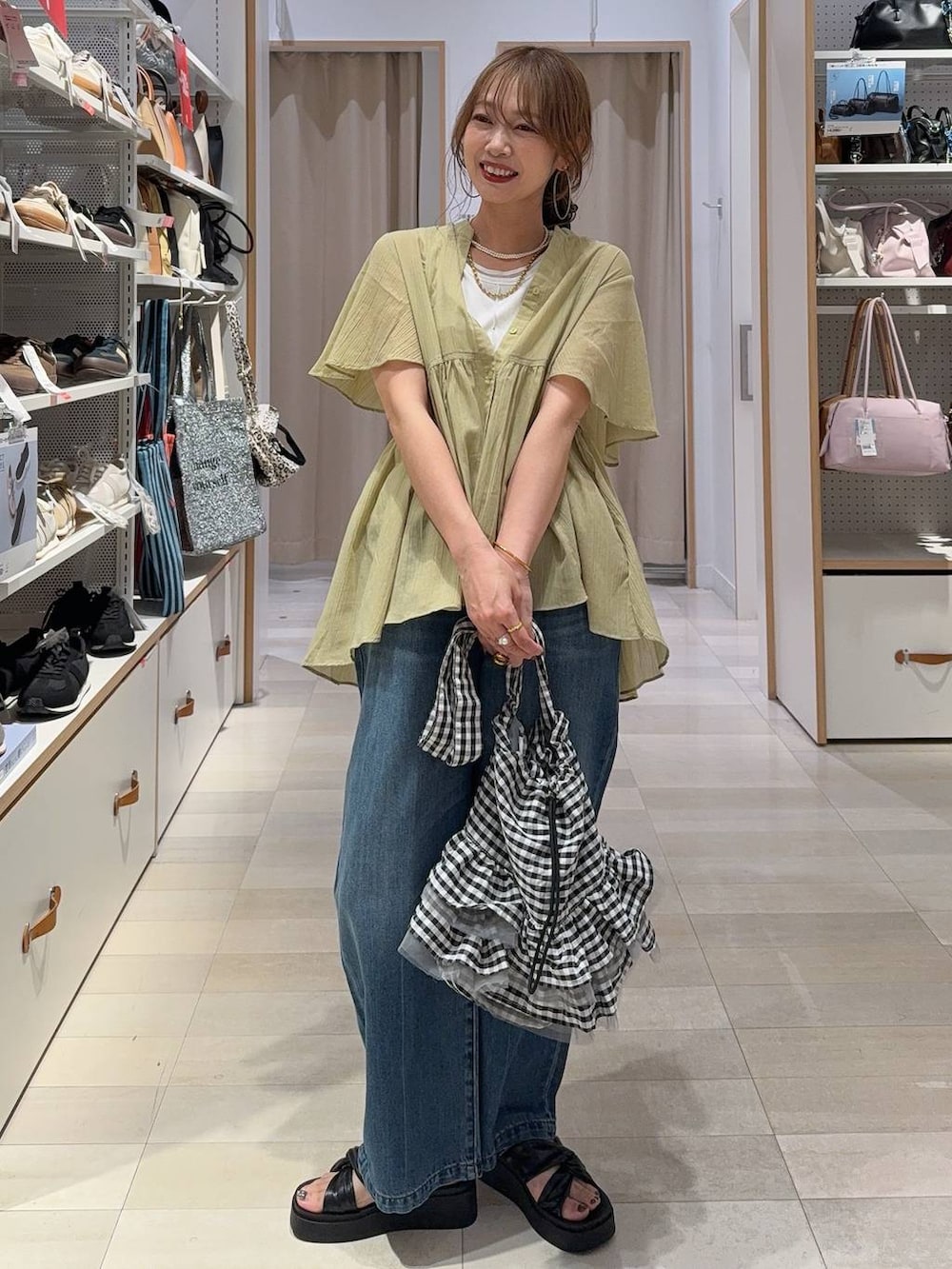 ブルー系のデニムパンツ、ブラウン系のワンピース、ブラック系のサンダルを着用したレディースの夏コーディネートの5枚目の写真
