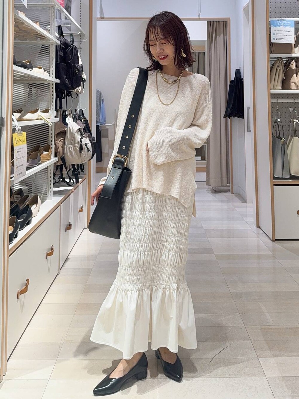 ホワイト系のスニーカー、ブラック系のキャミソール、ブラック系のハンドバッグを着用したレディースの秋コーディネートの2枚目の写真