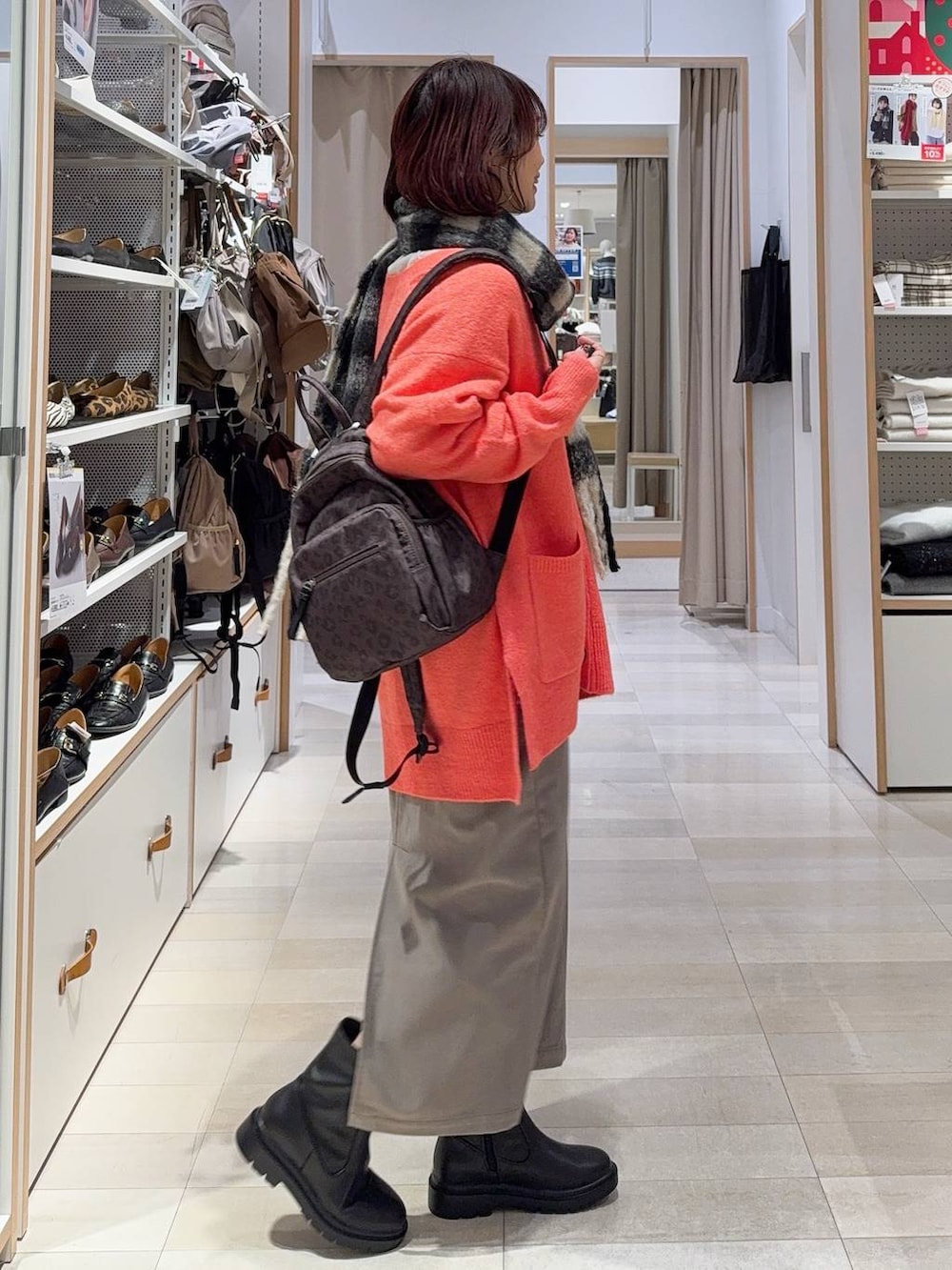 ブラウン系のバックパック/リュック、ブラウン系のスカート、ブラック系のブーツを着用したレディースの冬コーディネートの5枚目の写真