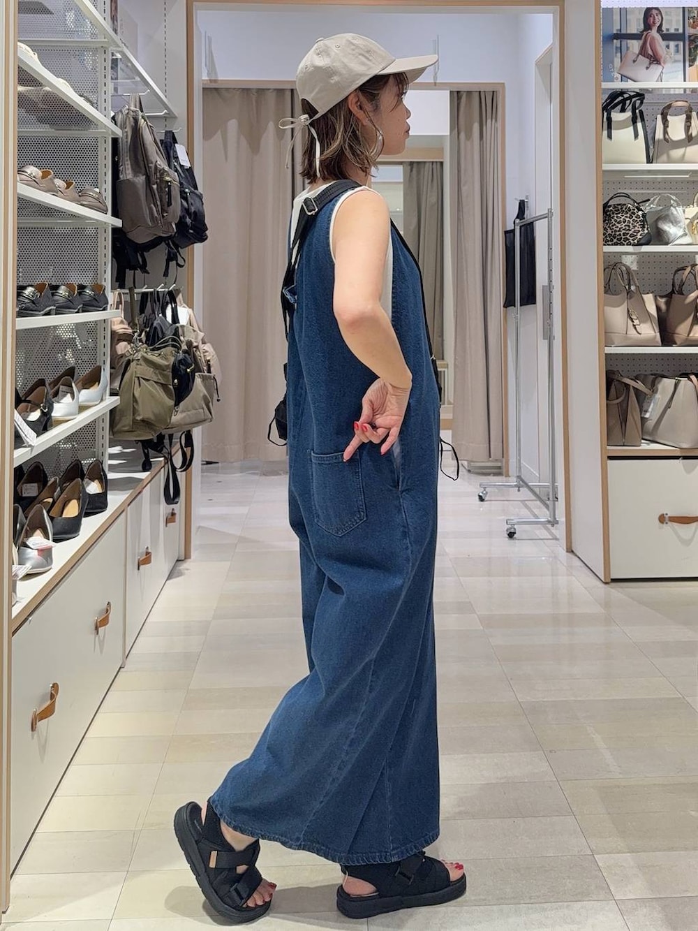 ブルー系のサロペット/オーバーオール、ピンク系のシャツ/ブラウス、ブラック系のショルダーバッグを着用したレディースの春コーディネートの8枚目の写真