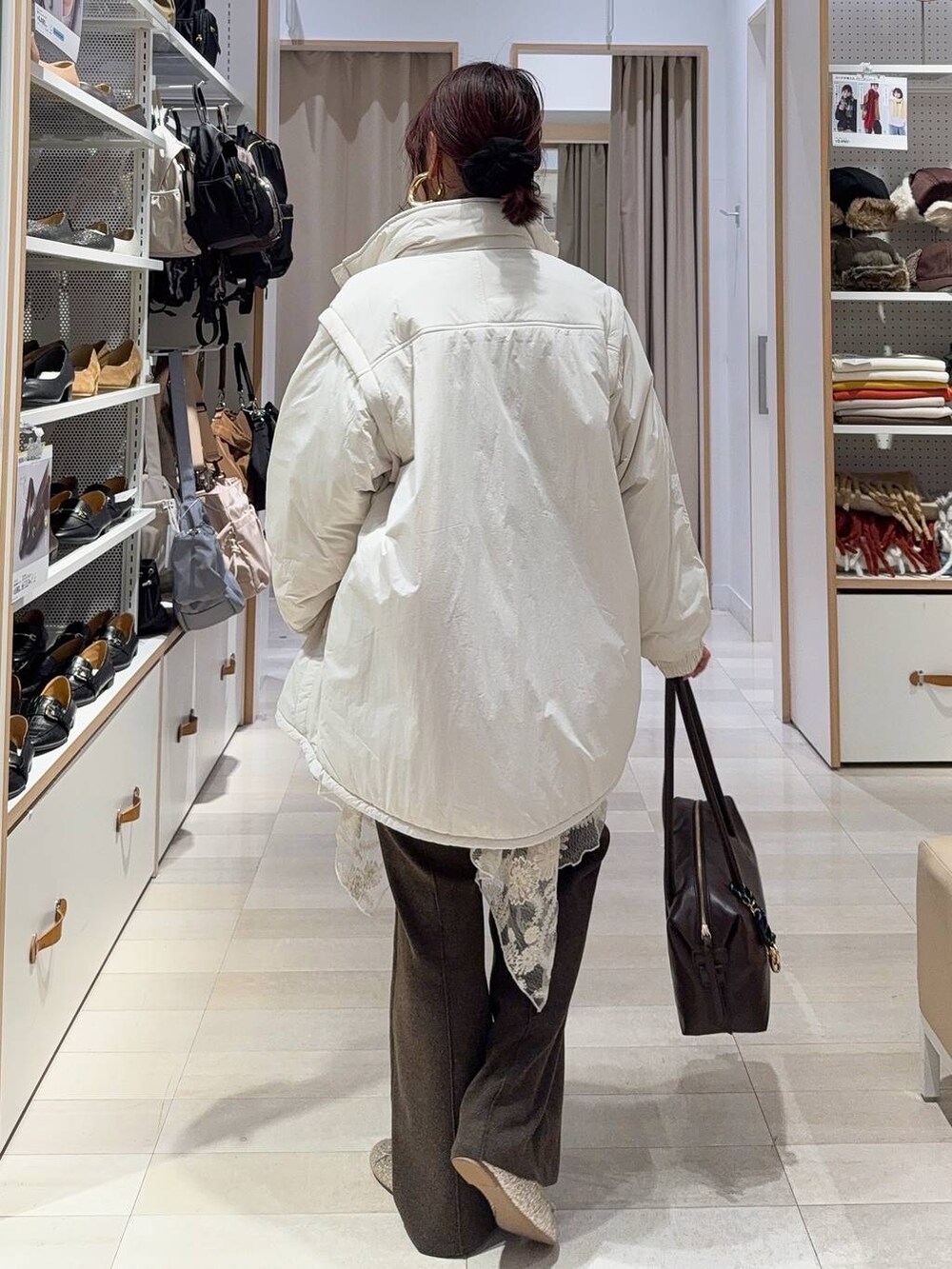 ゴールド系のバレエシューズ、ベージュ系のブルゾン、ブラウン系のボストンバッグを着用したレディースの冬コーディネートの4枚目の写真