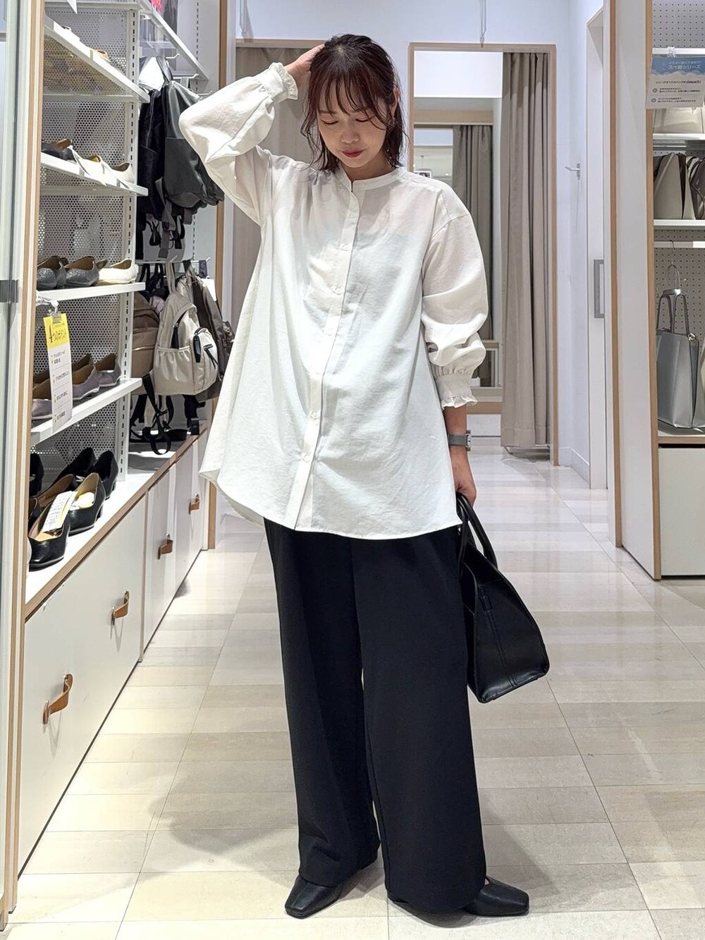 グレー系のカーディガン/ボレロ、ブラック系のショルダーバッグ、ホワイト系のシャツ/ブラウスを着用したレディースの秋コーディネートの2枚目の写真