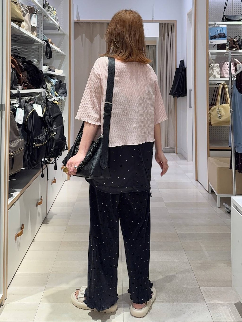 ホワイト系のキャミソール、ブルー系のデニムパンツ、ブラック系のニット/セーターを着用したレディースの春コーディネートの7枚目の写真