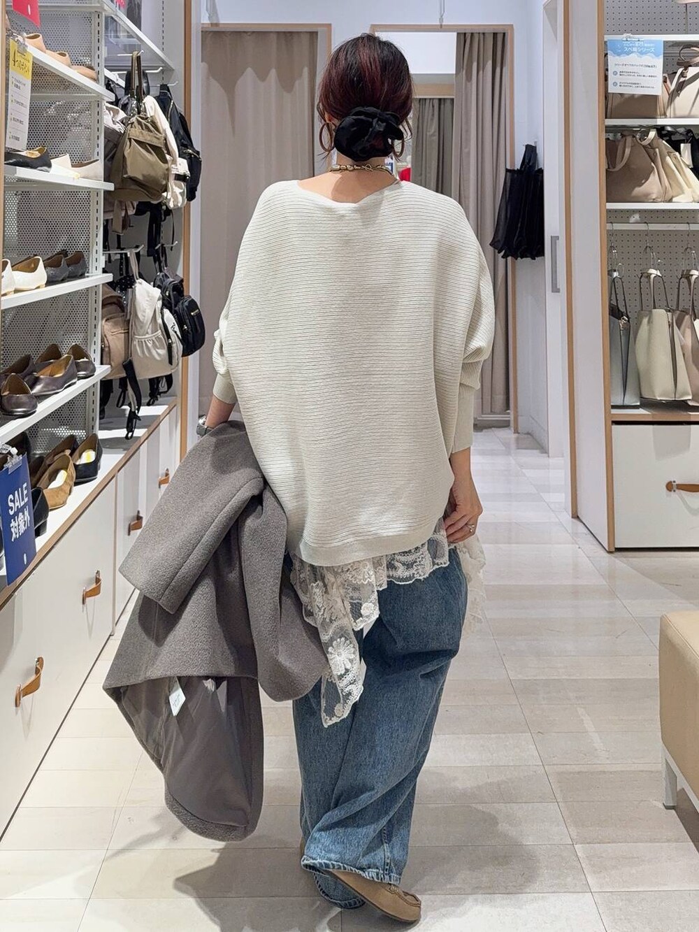 ブラウン系のボストンバッグ、ブルー系のデニムパンツ、ブラウン系のチェスターコートを着用したレディースの秋コーディネートの8枚目の写真