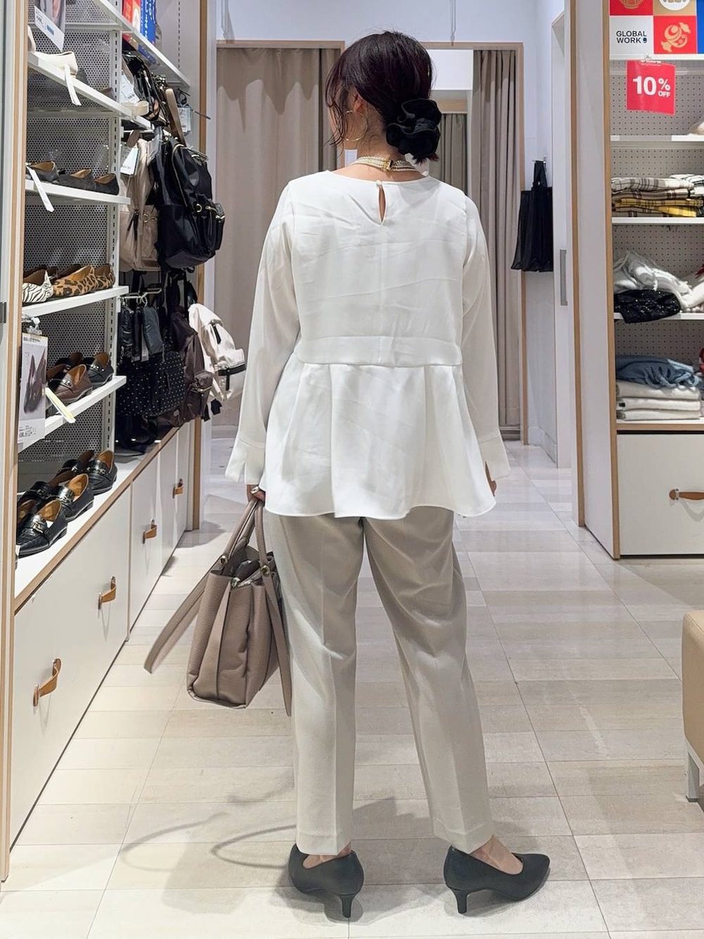 ブラック系のパンプス、ベージュ系のパンツドレス、ベージュ系のトートバッグを着用したレディースの冬コーディネートの7枚目の写真