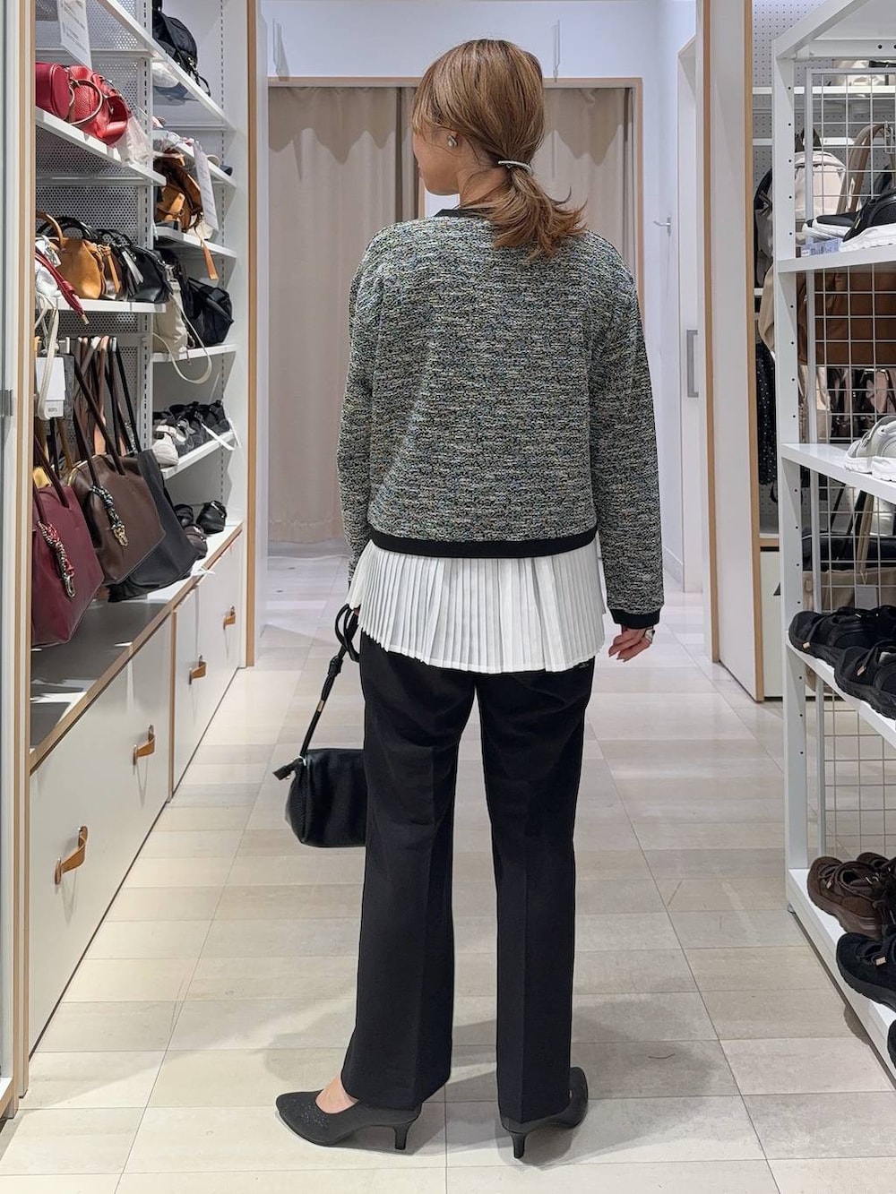 ブラック系のカーディガン/ボレロ、ブラック系のパンプス、ブラック系のショルダーバッグを着用したレディースの秋コーディネートの4枚目の写真