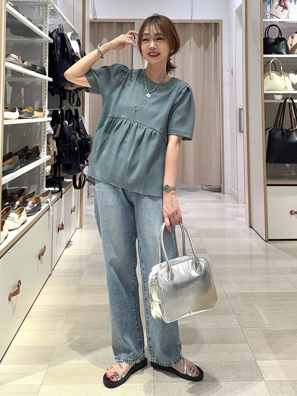 ブルー系のデニムパンツ、グレー系のボストンバッグ、ブラック系のカーディガン/ボレロを着用したレディースの夏コーディネートの3枚目の写真