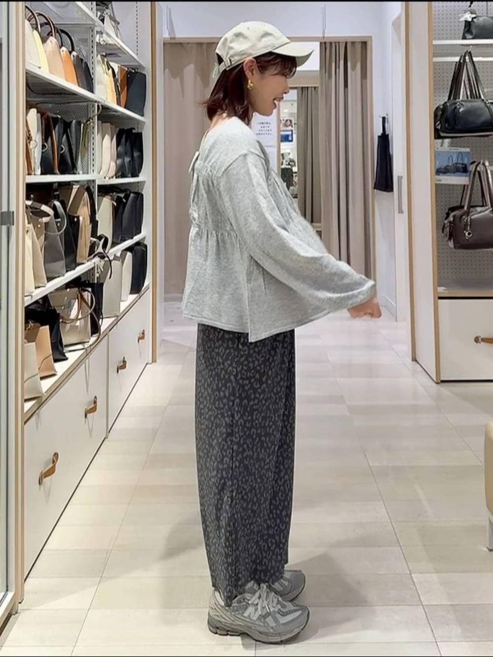 ブラック系のトートバッグ、ブラック系のマウンテンパーカー、グレー系のスカートを着用したレディースの春コーディネートの7枚目の写真