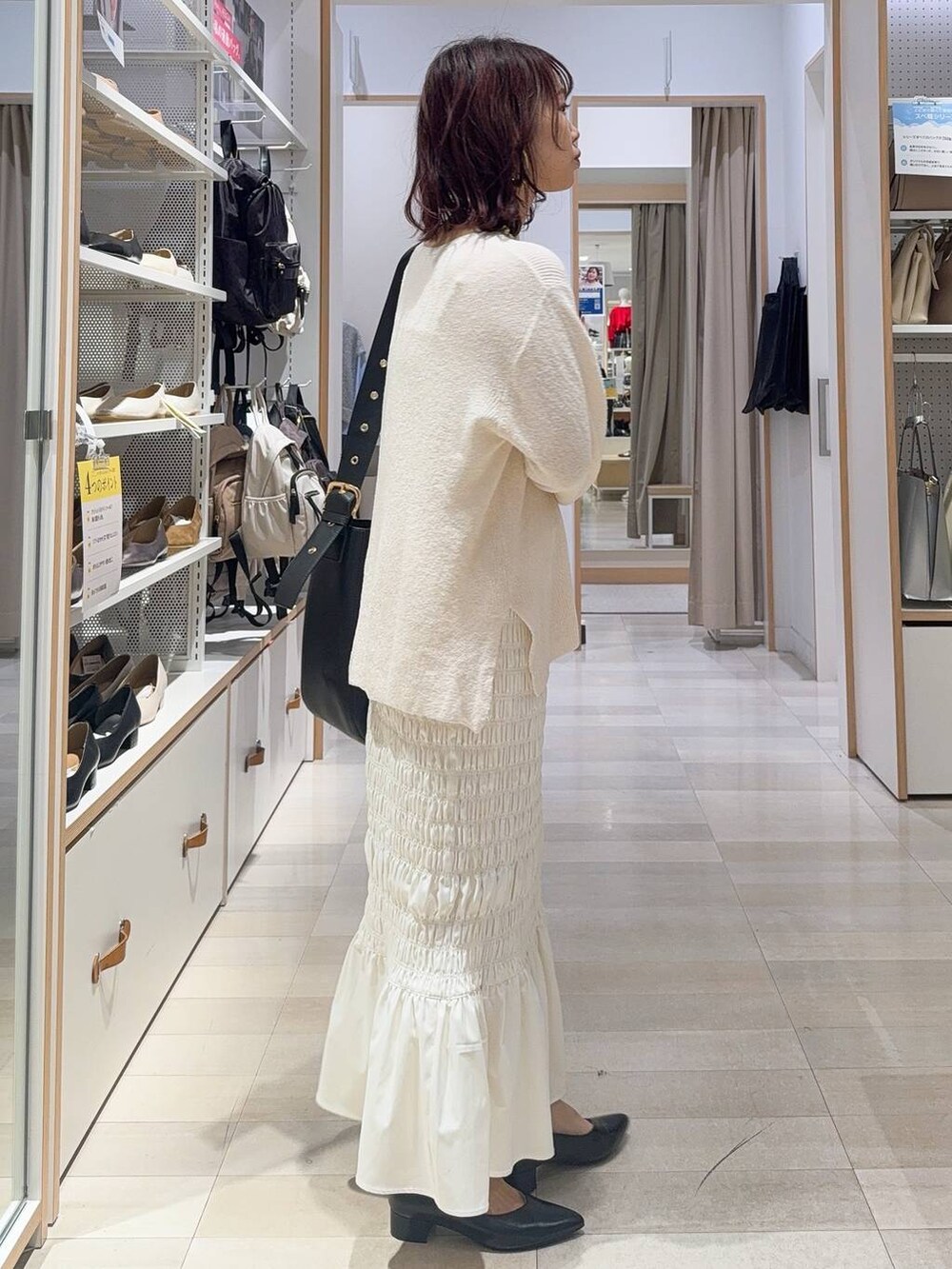 ホワイト系のスニーカー、ブラック系のキャミソール、ブラック系のハンドバッグを着用したレディースの秋コーディネートの6枚目の写真