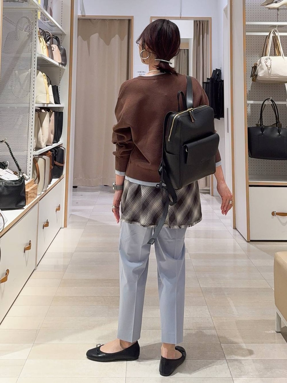 ブラック系のバレエシューズ、ブルー系のスラックス、ブラック系のバックパック/リュックを着用したレディースの冬コーディネートの7枚目の写真