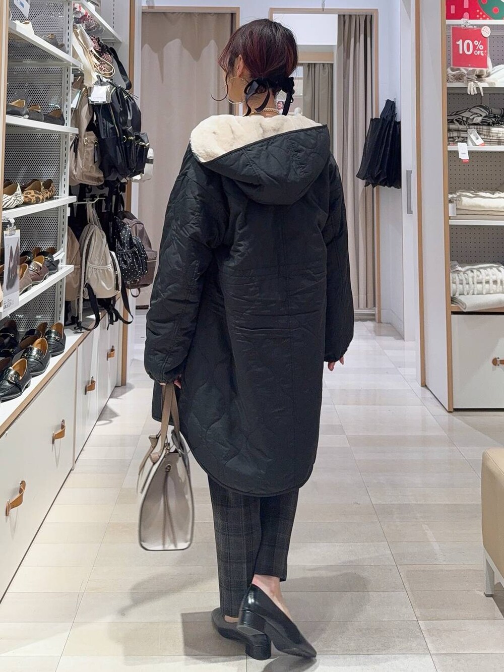 ホワイト系のショルダーバッグ、ブラック系のブルゾン、ブラック系のその他パンツを着用したレディースの冬コーディネートの5枚目の写真