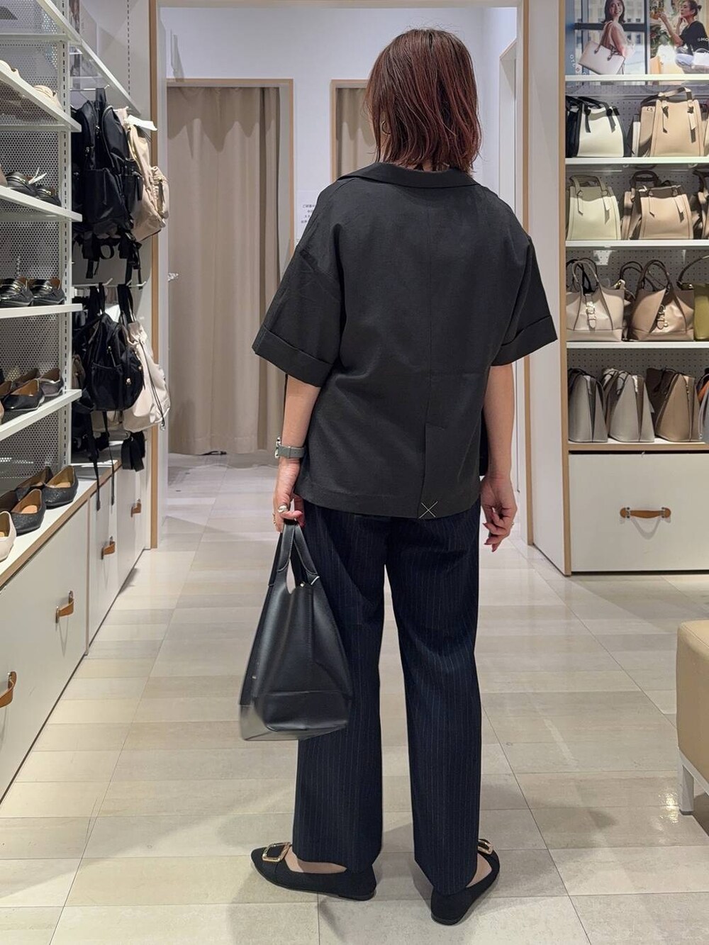 ブラック系のショルダーバッグ、ブラック系のパンプス、ブルー系のその他パンツを着用したレディースの夏コーディネートの5枚目の写真