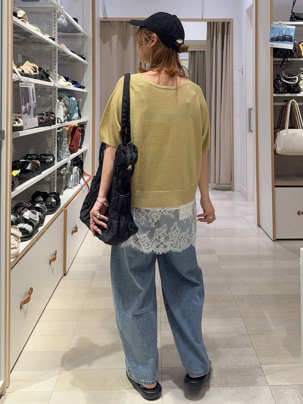イエロー系のTシャツ/カットソー、ブラック系のトートバッグ、ブルー系のデニムパンツを着用したレディースの夏コーディネートの5枚目の写真