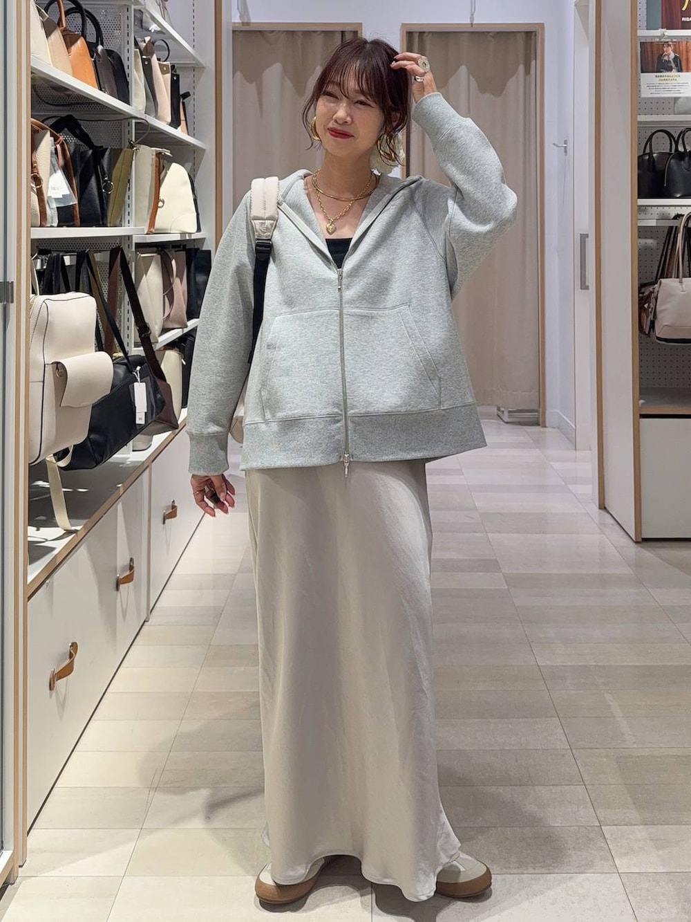 ブラック系のTシャツ/カットソー、グレー系のスカート、ブラウン系のスウェットを着用したレディースの春コーディネートの3枚目の写真