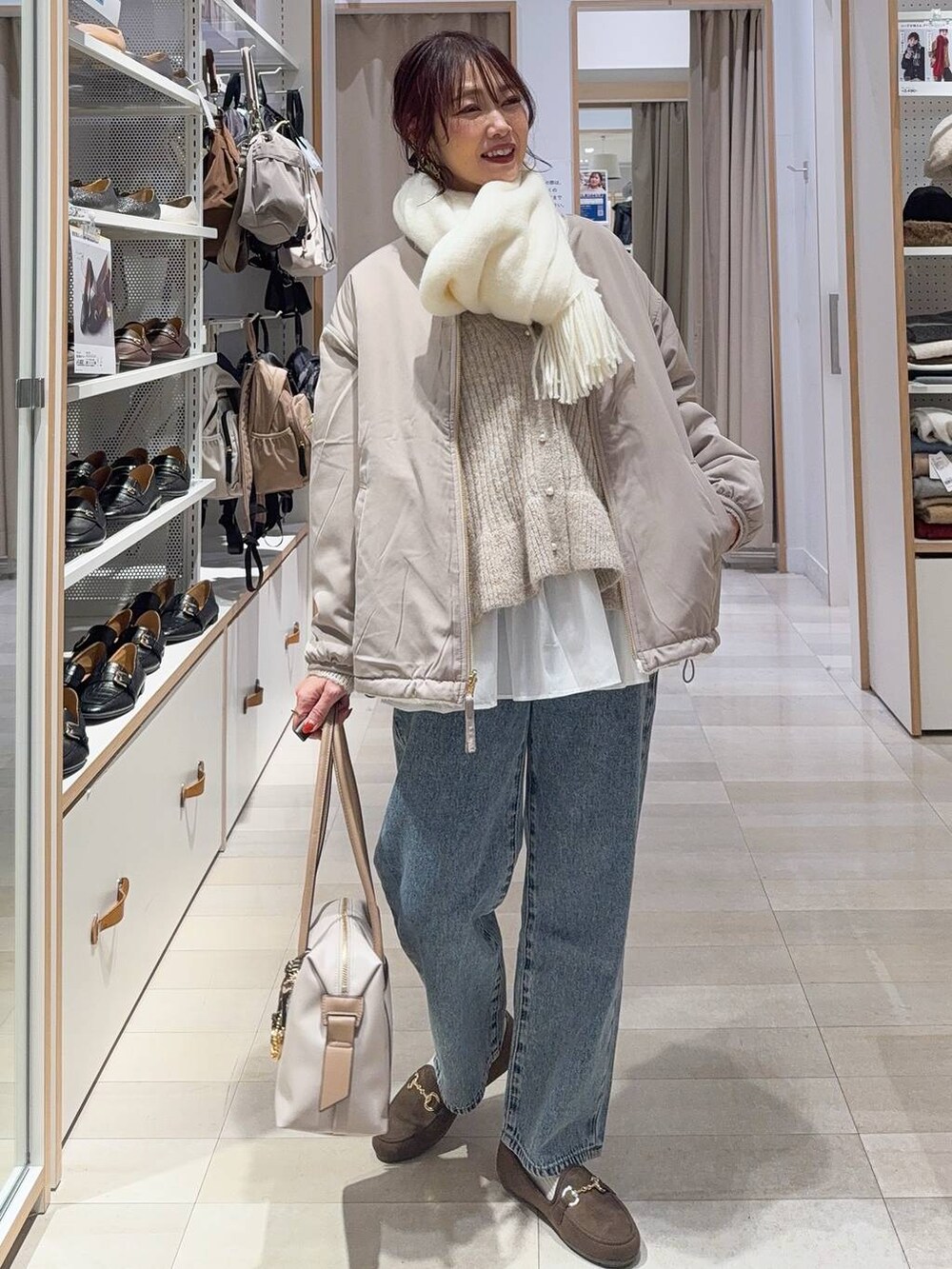 グレー系のバレエシューズ、ブルー系のトートバッグ、ホワイト系のブルゾンを着用したレディースの秋コーディネートの3枚目の写真