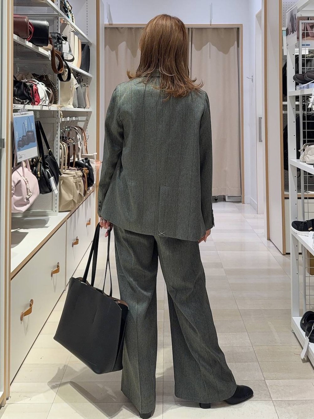 グレー系のその他パンツ、ブラック系のブーツ、ブラック系のトートバッグを着用したレディースの秋コーディネートの5枚目の写真
