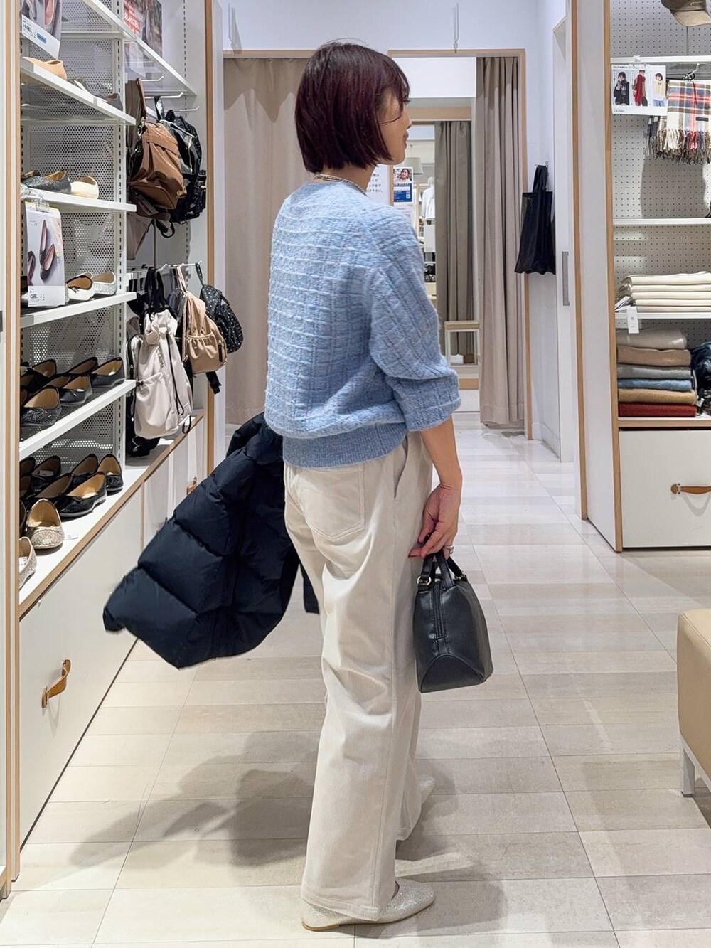 ブラック系のショルダーバッグ、シルバー系のパンプス、ブルー系のダウンジャケット/コートを着用したレディースの秋コーディネートの6枚目の写真