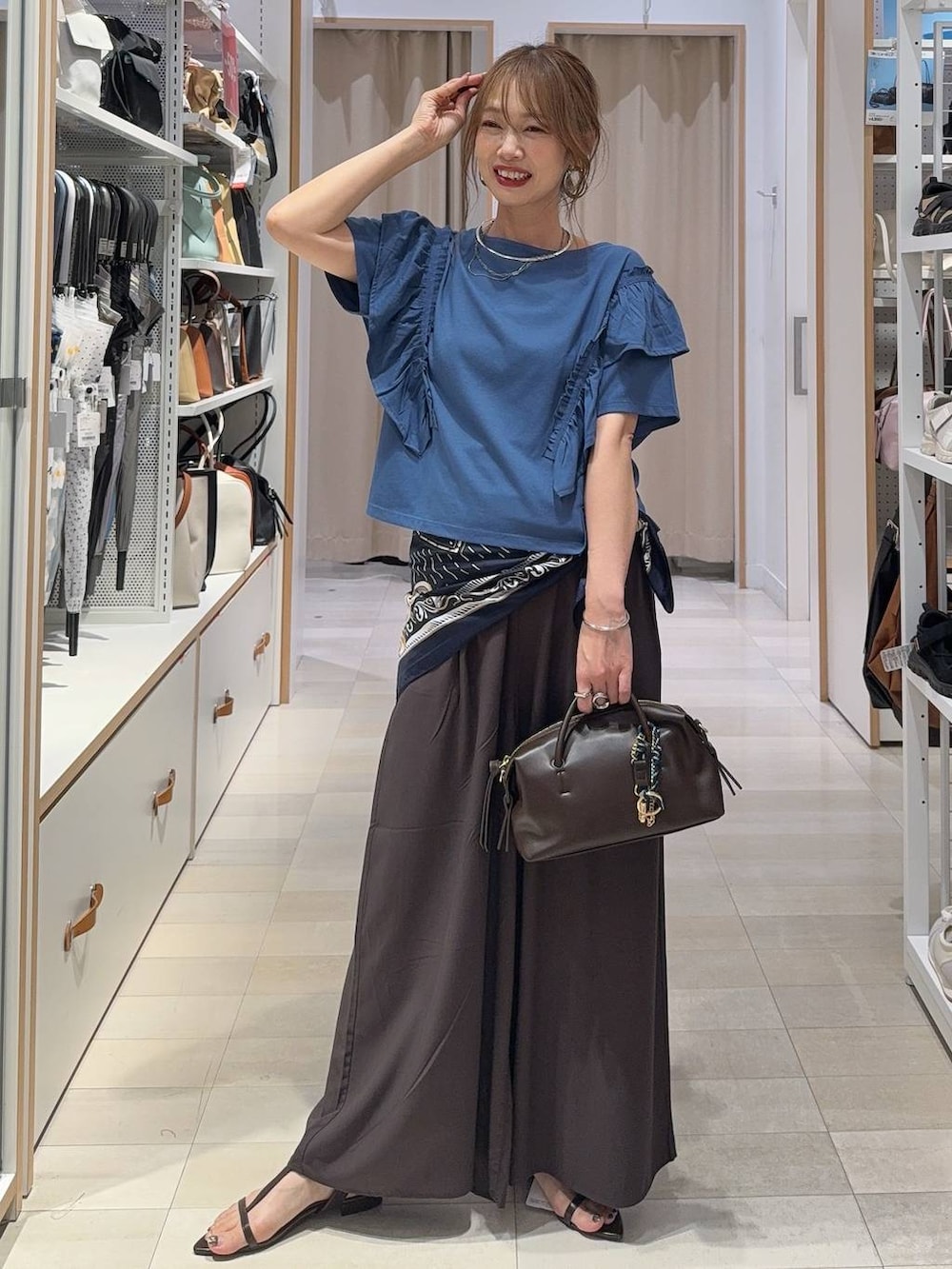 シルバー系のショルダーバッグ、ベージュ系のその他パンツ、ブルー系のTシャツ/カットソーを着用したレディースの夏コーディネートの2枚目の写真