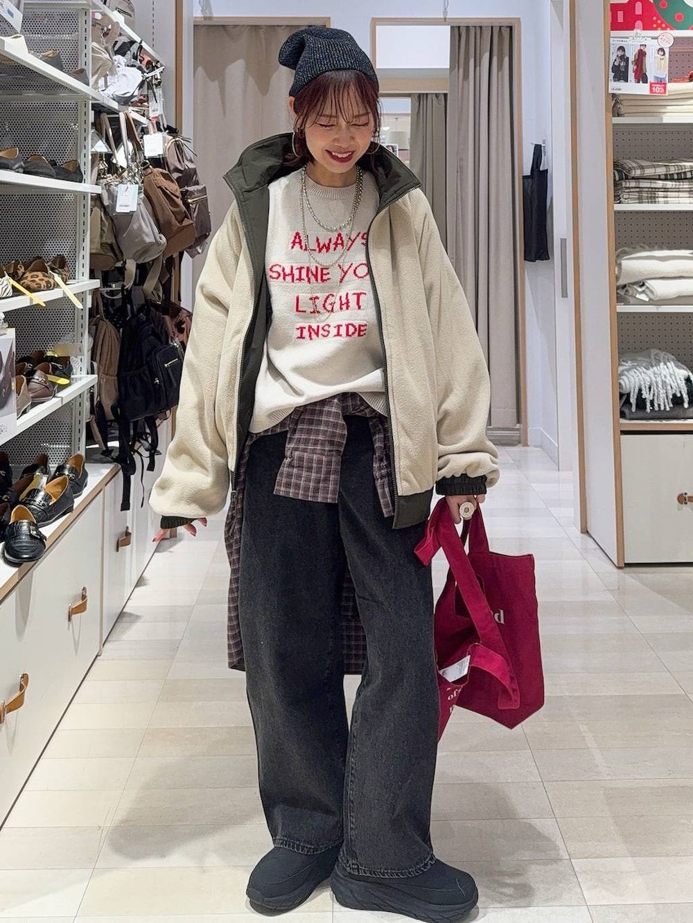 ブラック系のデニムパンツ、ブラウン系のシャツ/ブラウス、レッド系のトートバッグを着用したレディースの冬コーディネートの2枚目の写真