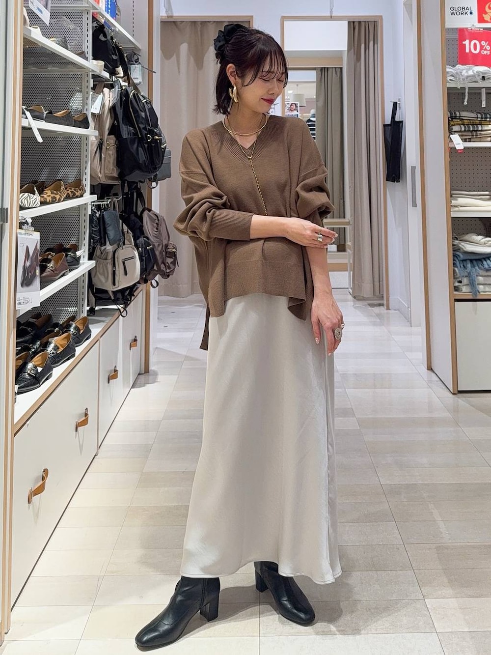 ブラウン系のチェスターコート、ブラック系のその他パンツ、ホワイト系のTシャツ/カットソーを着用したレディースの冬コーディネートの3枚目の写真