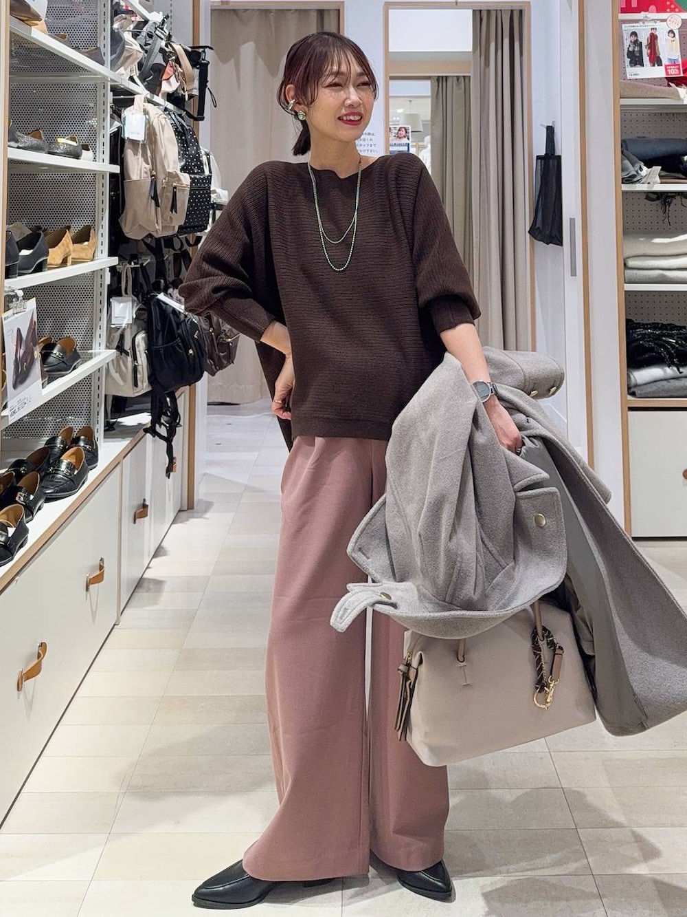 ブラック系のダウンジャケット/コート、ブラック系のボストンバッグ、ブルー系のデニムパンツを着用したレディースの冬コーディネートの4枚目の写真