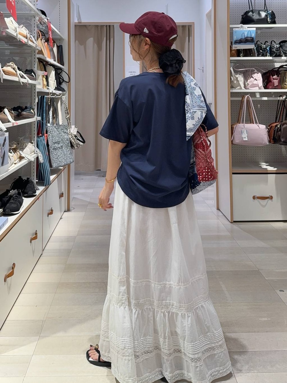 ホワイト系のスカート、ブルー系のTシャツ/カットソー、ブラック系のサンダルを着用したレディースの夏コーディネートの5枚目の写真
