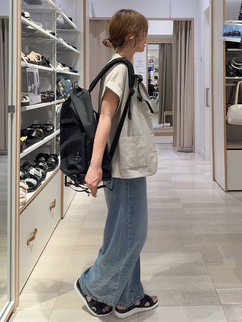ブルー系のデニムパンツ、ブラウン系のタンクトップ、ベージュ系のシャツ/ブラウスを着用したレディースの夏コーディネートの3枚目の写真