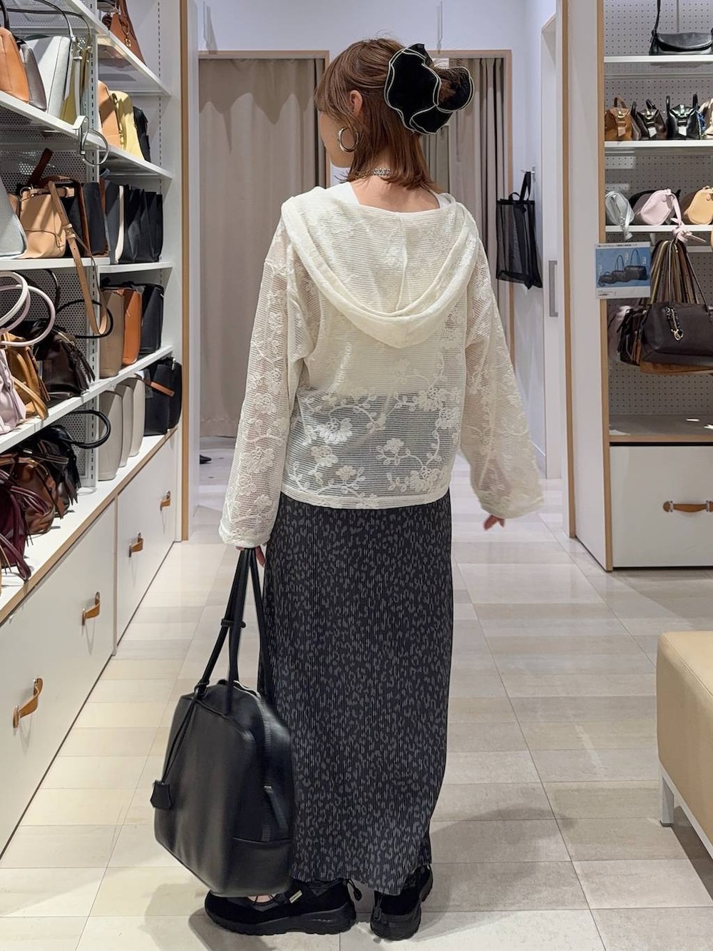 ベージュ系のパーカー、ホワイト系のタンクトップ、ブラック系のトートバッグを着用したレディースの春コーディネートの4枚目の写真